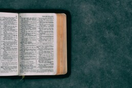 open pocket bible on green surface